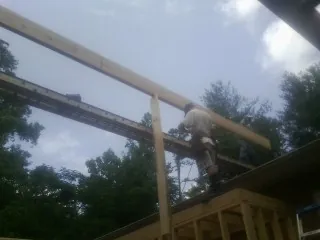 Carpenter setting a ridge beam over a new addition frame — Ice Dam Removal by Roofing Brothers in Dushore