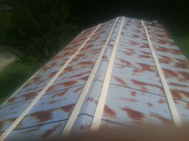 Rusted metal roof panels with new wood purlins before replacement — Storm Damage Roof Repair in Dushore by Roofing Brothers