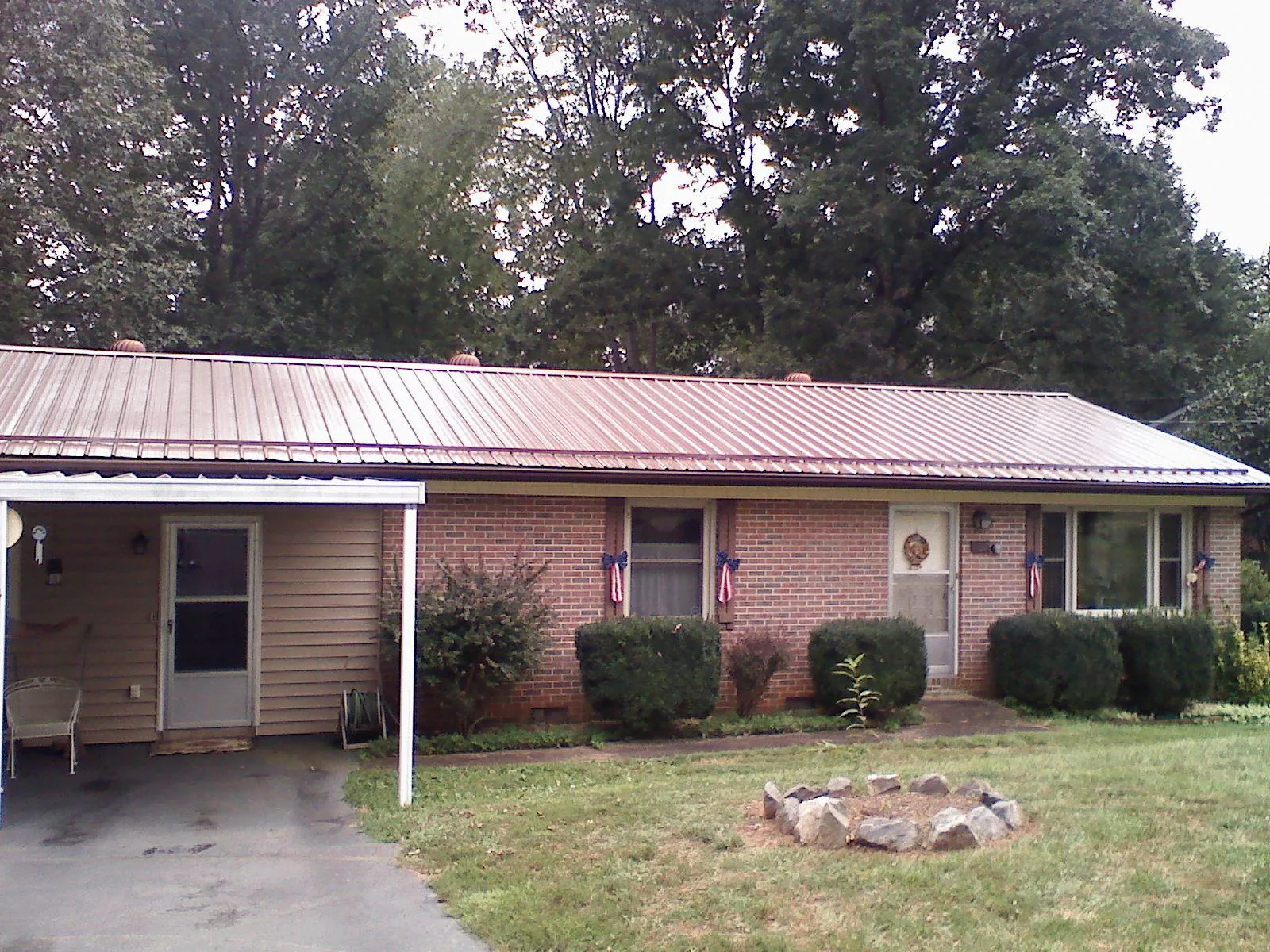Bronze metal roof and carport on a brick ranch home — Roof Repair work by our crew in Dushore